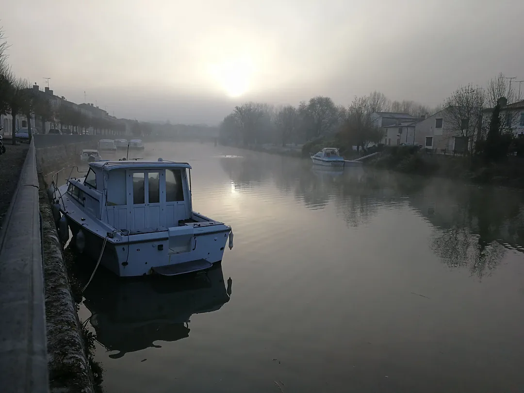Bateau amarré sur la rivière, un matin de brume