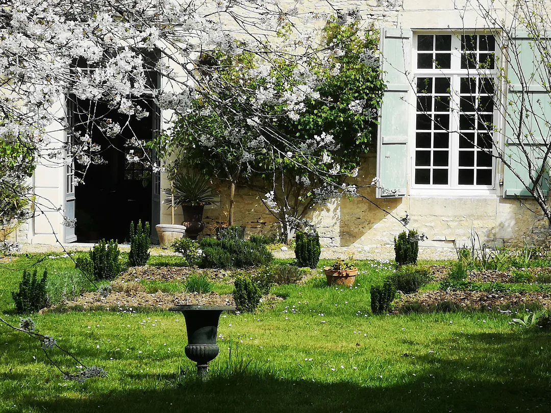 L'entrée du logis encadrée de branches fleuries