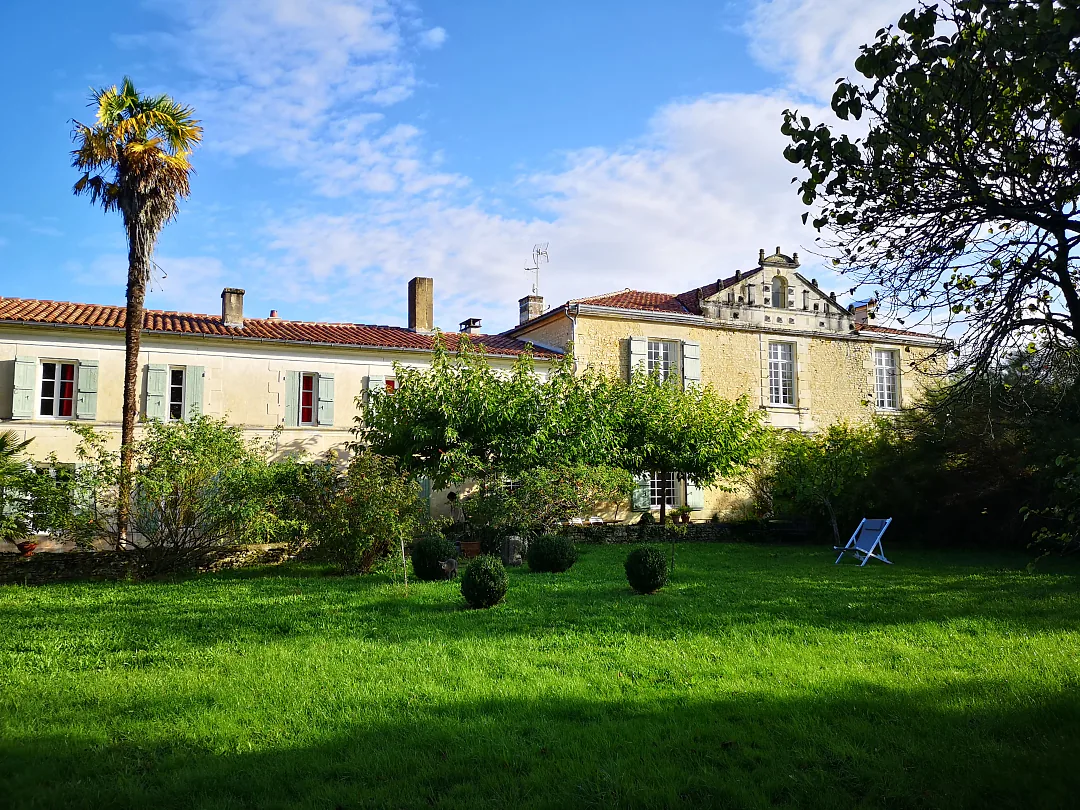 Le logis et sa pelouse, palmier et massifs