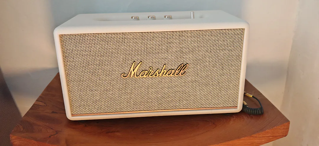 Enceinte Marshall blanche posée sur une console en bois