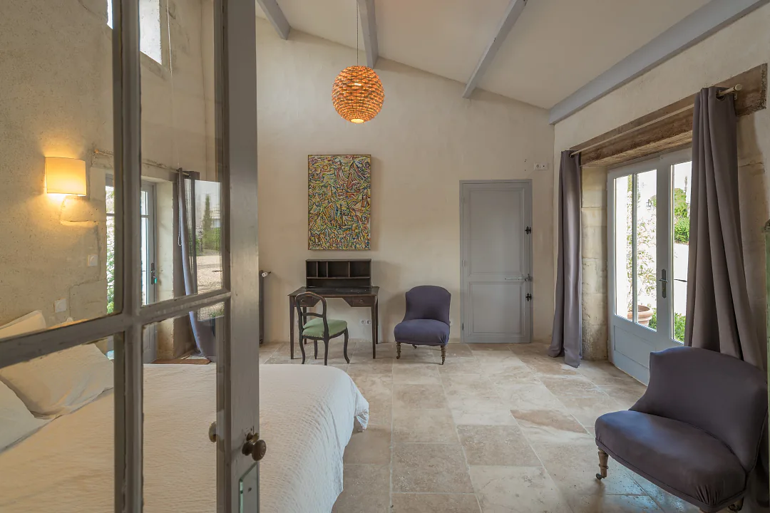 Chambre de Bons Bois vue depuis la porte vitrée, fauteuils et bureau près de la fenêtre