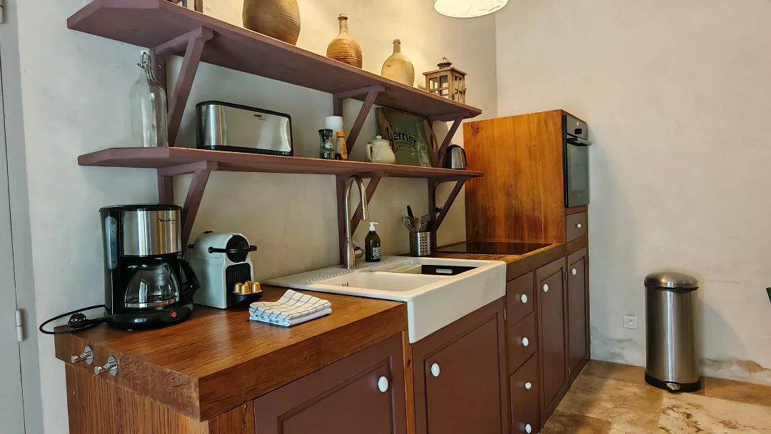 Plan de travail en bois de Bons Bois, évier, cafetière et étagères garnies de céramiques