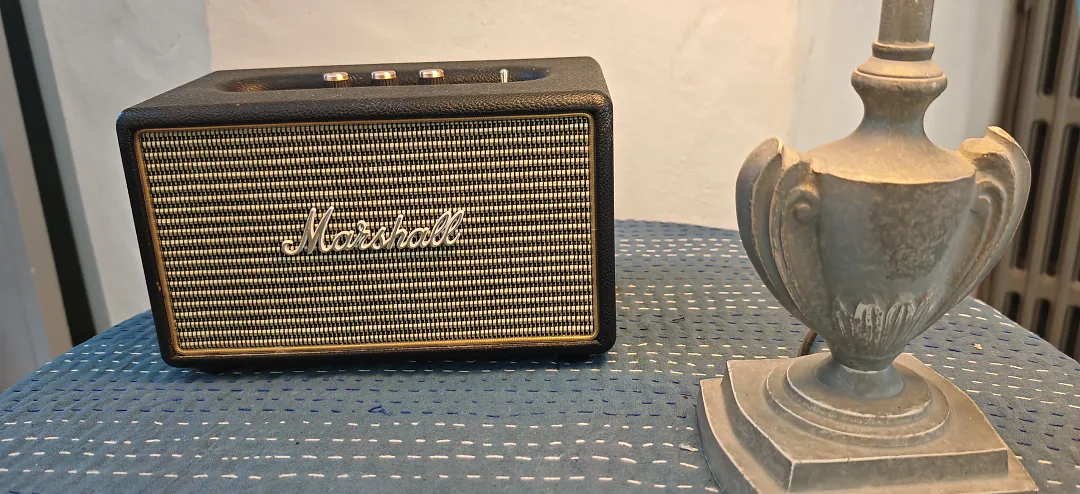 Enceinte Marshall et pied de lampe ancien posés sur une console