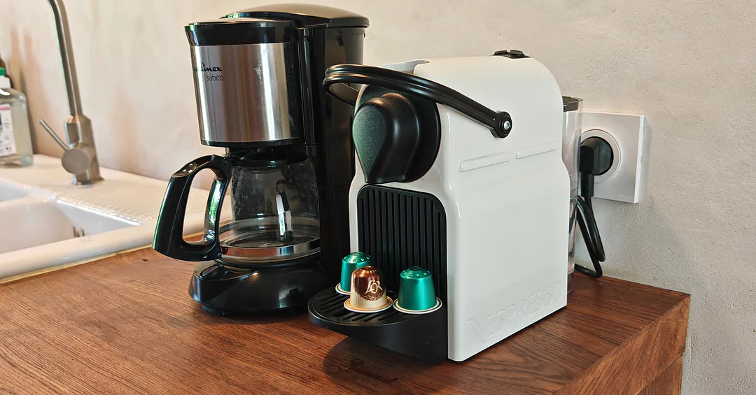 Cafetière filtre et machine à capsules sur le plan de travail en bois