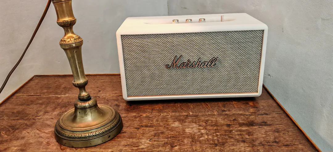 Enceinte Marshall blanche et pied de lampe en laiton sur une console