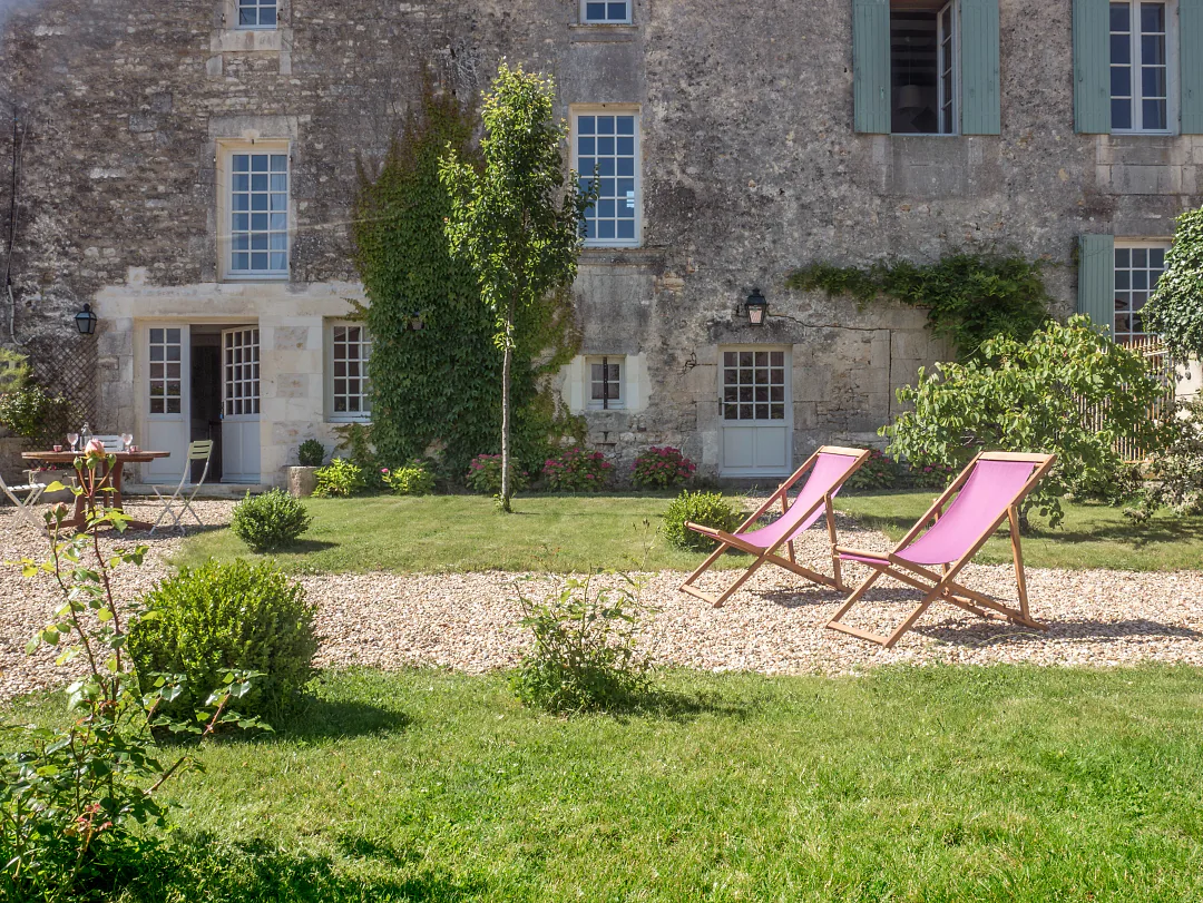 Deux transats roses sur la pelouse du jardin clos de Grande Champagne