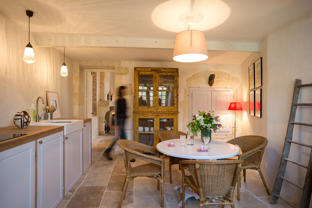 Cuisine et coin repas de Grande Champagne, plan de travail clair et table ronde fleurie