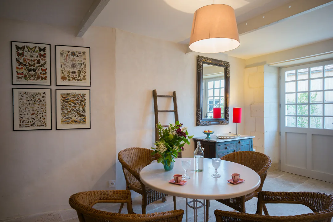 Table ronde dressée de Grande Champagne sous les gravures encadrées, miroir et console