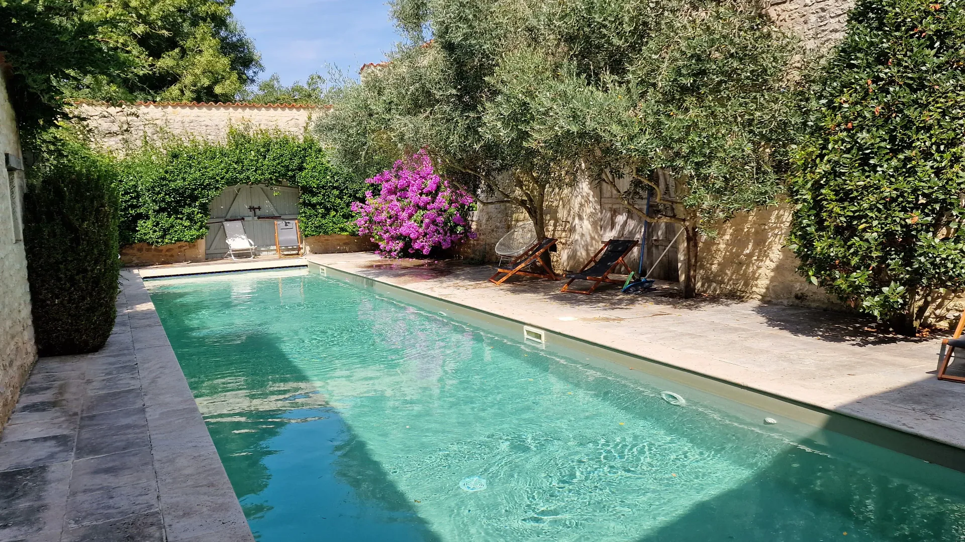 La piscine du Logis entre les murs de pierre, un matin d'été